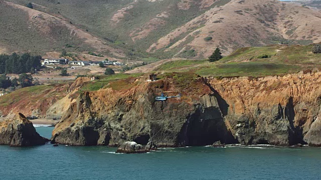 一架空中直升机在海边的悬崖边飞行视频素材