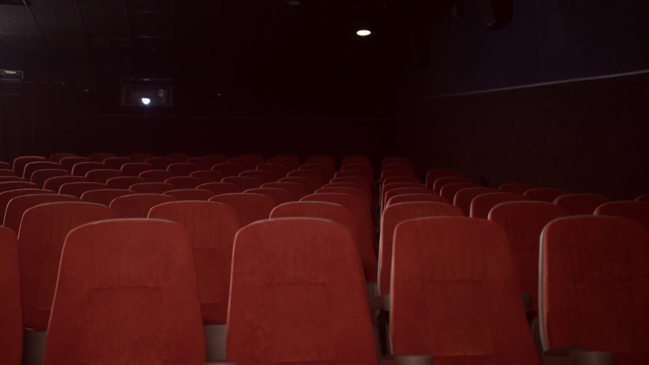 电影院的空座位。空荡荡的剧院大厅里摆着红色的扶手椅视频素材