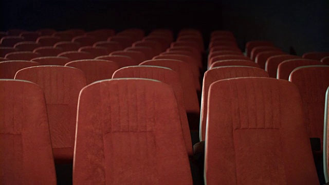电影院里一排排的空座位。剧院里的空扶手椅。视频素材