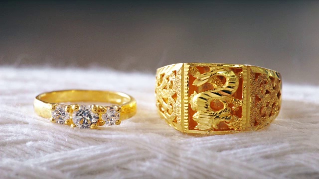 微距拍摄的金色结婚戒指与白色纹理的背景。视频下载