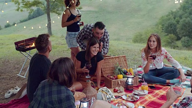 一群朋友花时间野餐和烧烤。慢动作拍摄视频素材