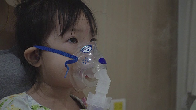 一个亚洲小女孩正在医院接受雾化吸入治疗。视频素材