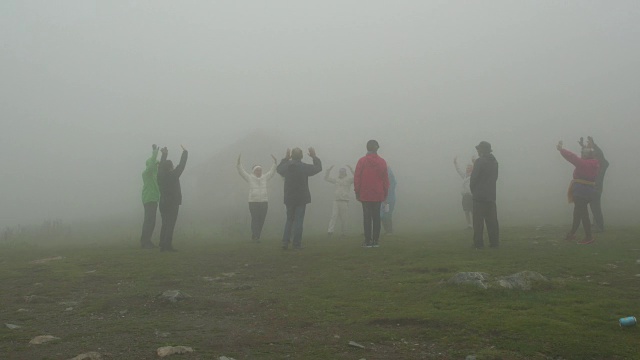 世界白人兄弟会的一群追随者在瑞拉山在一个雾蒙蒙的天气练习呼吸练习和泛音节奏舞视频下载