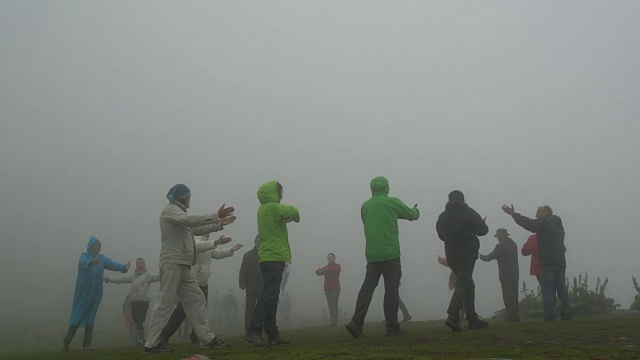 世界白人兄弟会的一群追随者在瑞拉山在一个雾蒙蒙的天气练习呼吸练习和泛音节奏舞视频素材