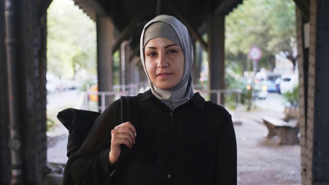 一个背着背包的穆斯林女性旅行者的肖像(慢镜头)视频下载