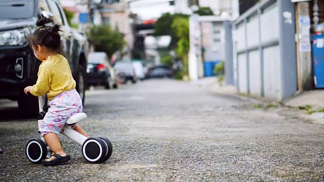 年轻快乐的亚洲小女孩骑着自行车。视频素材