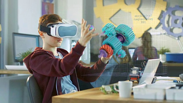 在计算机科学课上，男孩戴着虚拟现实头盔在交互式3D环境中工作。用增强现实软件连接齿轮的机械建模项目。视频下载