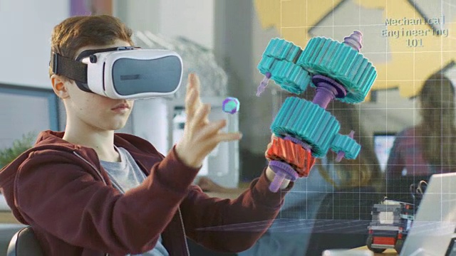 在计算机科学课上，男孩戴着虚拟现实头盔在交互式3D环境中工作。用增强现实软件连接齿轮的机械建模项目。视频素材