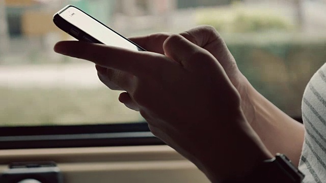 坐出租车，用智能手机上网的亚洲女性视频素材