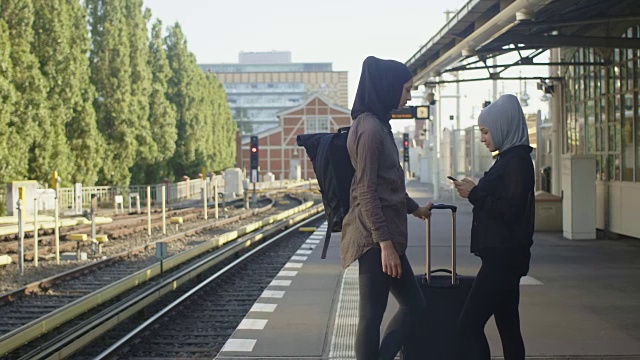 两位穆斯林女性朋友在柏林等地铁(慢镜头)视频素材