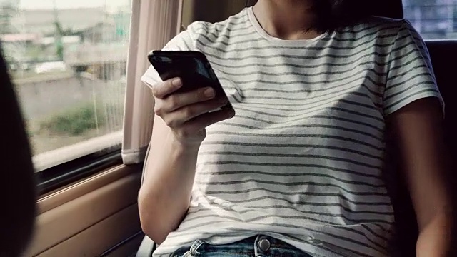 坐在车后座上用信用卡打电话的亚洲女人视频素材