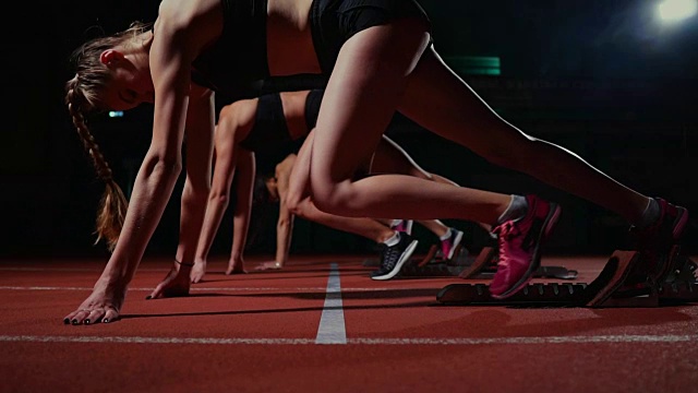 女运动员在赛跑前在跑道上热身。在慢动作视频素材