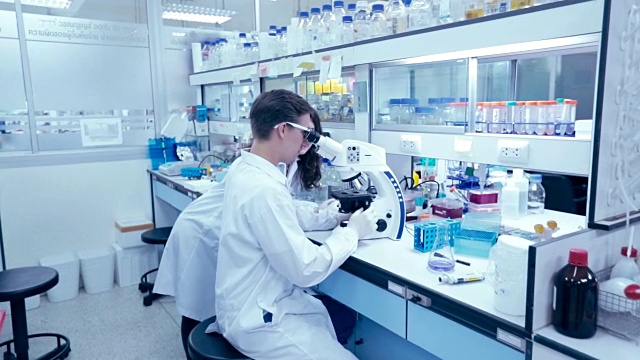 研究人员在实验室里观察显微镜，概念科学，慢动作视频下载