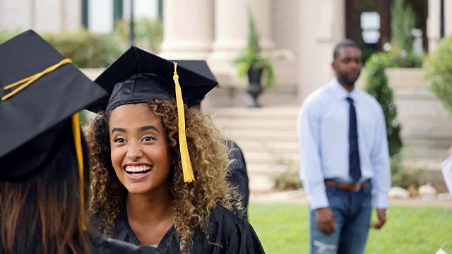 美丽的混血女大学毕业生毕业后拥抱她的朋友视频素材