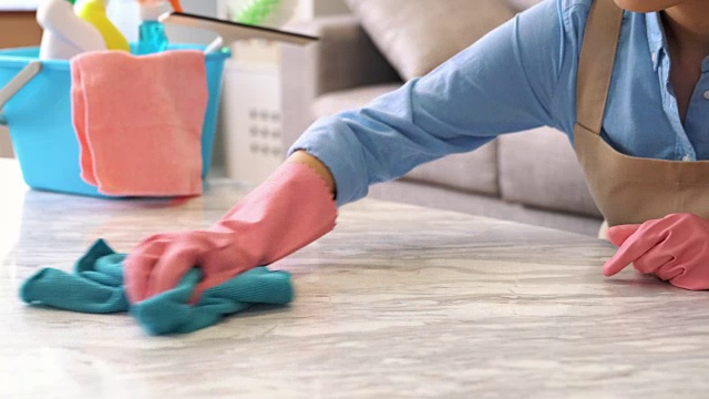 戴黄手套的家庭主妇在清洁桌子视频下载