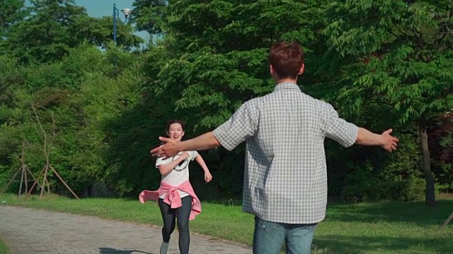 一个女学生在公园里跑步，被他的男朋友抱着视频素材
