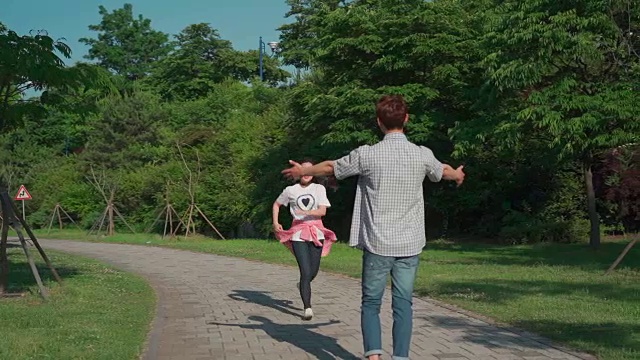 一个女学生在公园里跑步，被他的男朋友抱着视频素材