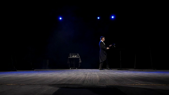 舞台上的魔术师从黑暗中出现视频下载