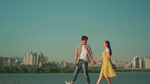 一对年轻的夫妇在汉江公园里手拉手散步视频素材
