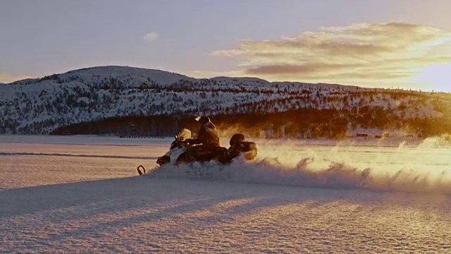 日落时分，骑着雪地摩托穿过雪地视频下载