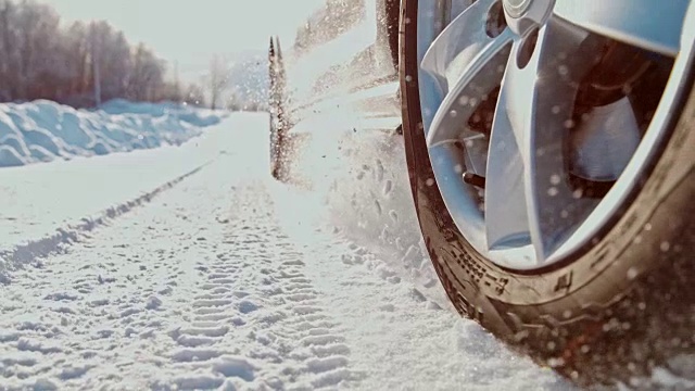 SLO MO汽车的轮子在雪中旋转视频素材