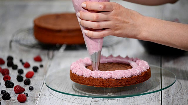 准备制作浆果巧克力蛋糕。女人的手装饰蛋糕视频素材