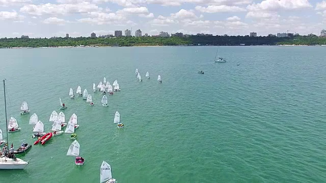 鸟瞰图的小游艇在海上训练与城市的背景视频素材