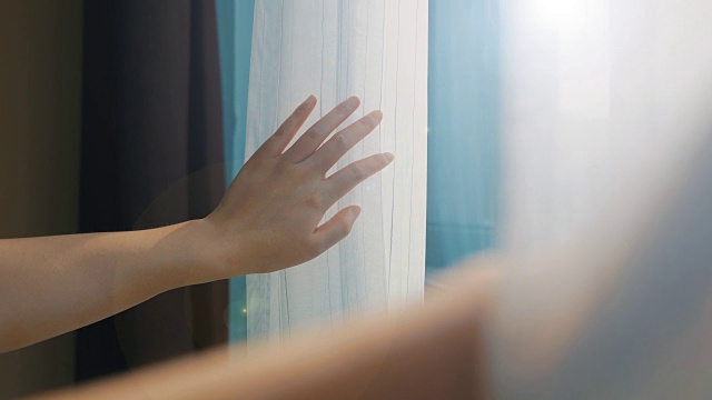 女人用手拉开窗帘视频素材