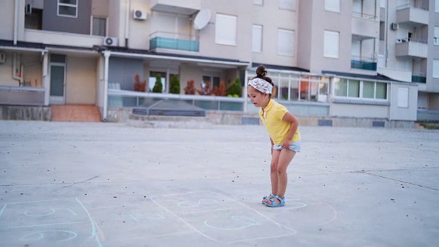 好奇的小女孩玩跳房子游戏视频素材