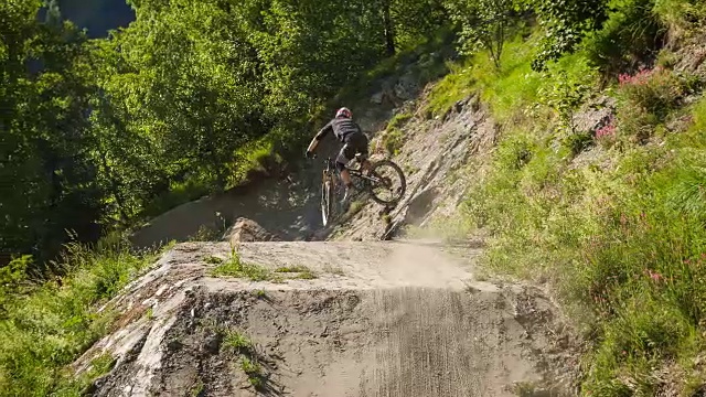下坡山地车骑在土路上，表演跳跃特技自行车鞭运动坡道视频素材