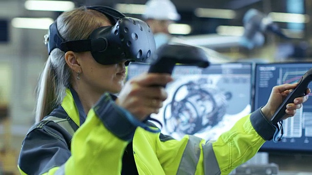 戴着虚拟现实头戴和手持控制器的女性工业工程师，她在CAD软件中使用VR技术进行工业设计、开发和原型。视频素材
