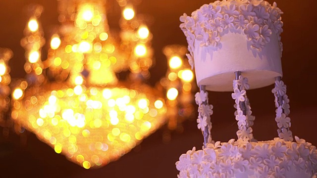 美丽的白色婚礼蛋糕与吊灯的背景与复制空间视频素材