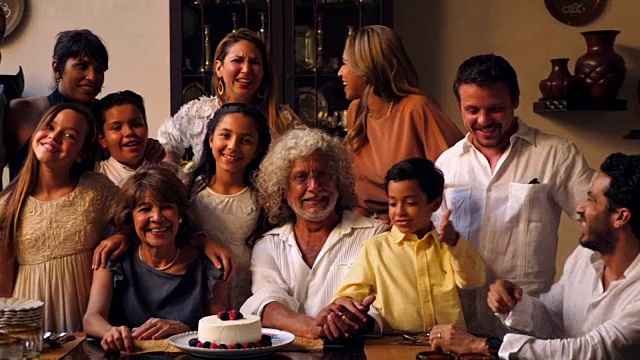 几代同堂的家庭聚在餐桌上吃生日晚餐的照片视频下载