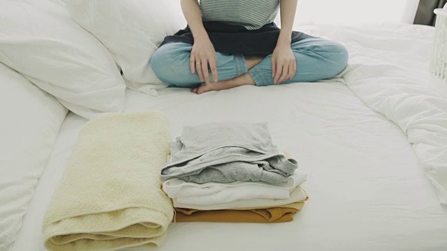 在床上叠衣服的女人视频素材