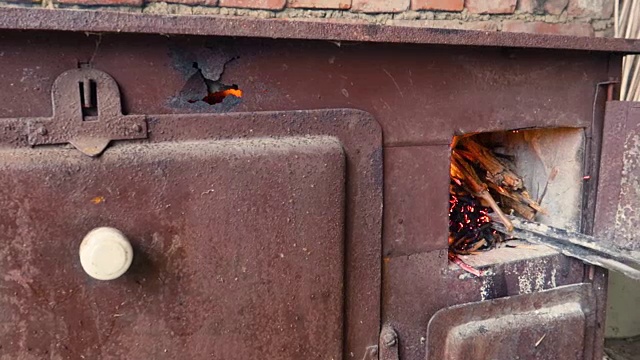烧木头的炉子正在烧饭，小孩打开一扇门，看到烧着的树枝、灌木视频下载