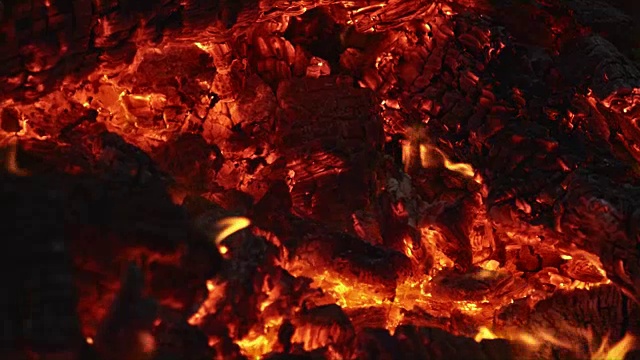明亮的火焰从木头燃烧在火在夜晚，慢镜头视频下载
