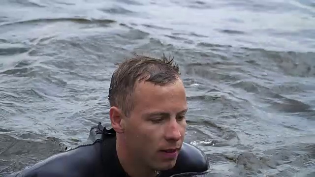 一个穿着潜水服的帅哥正在河里游泳视频素材