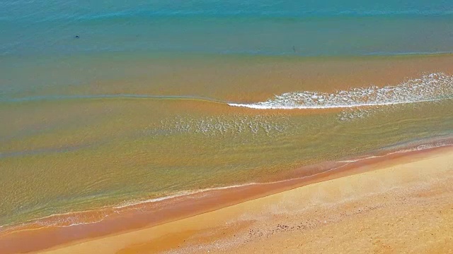 阳光明媚的日子，透明的波浪在沙滩上翻滚视频素材