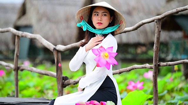 越南妇女抱着莲花坐在莲花地里，越南视频素材