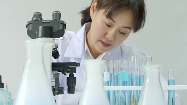 在实验室里通过显微镜观察的亚洲女性医学研究科学家视频购买