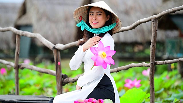 越南妇女抱着莲花坐在莲花地里，越南视频素材