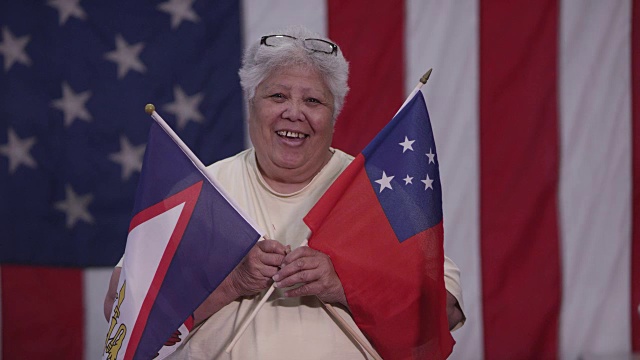手持萨摩亚和美属萨摩亚国旗的妇女视频下载