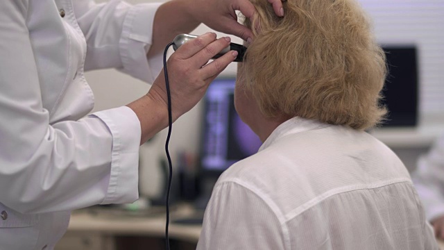 护士检查一位成年妇女的耳朵。视频下载
