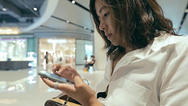 美丽的年轻女子迷人的近距离使用移动智能手机在购物中心视频素材