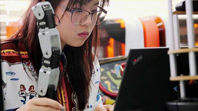十几岁的工作在一个全功能可编程机器人为她的学校机器人俱乐部项目。创意设计师在车间测试机器人原型。科学概念视频素材
