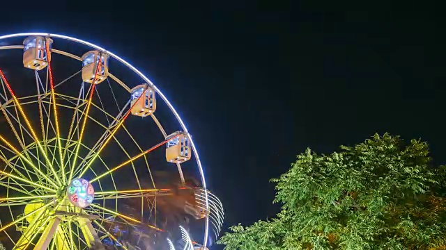 旋转在自然运动效果照明吸引摩天轮晚上在城市游乐场视频素材