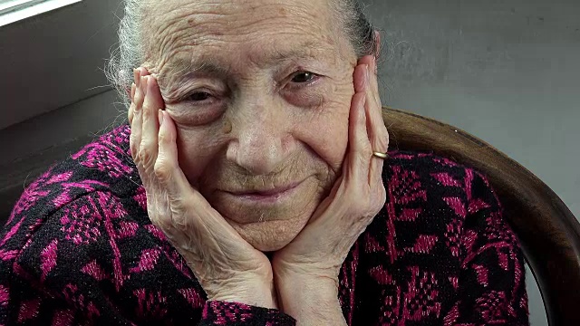 悲伤的老女人独自坐在家里:一个孤独的老女人的特写视频素材