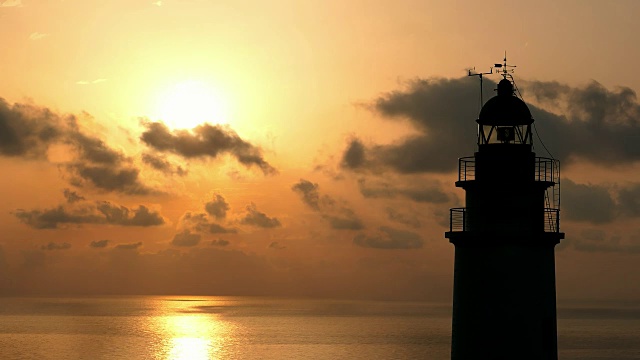 日出时，马略卡岛上岩石悬崖上的灯塔和壮观的云彩视频素材