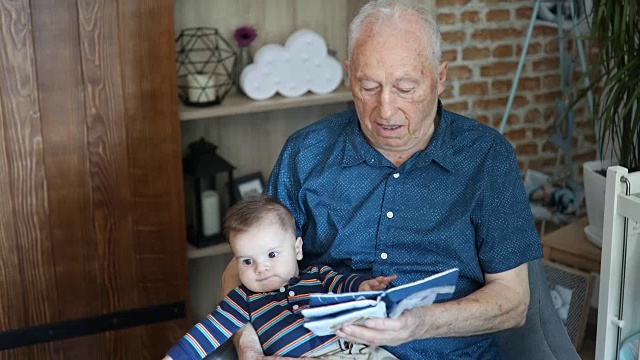 曾祖父和他的曾孙一起看婴儿书视频下载