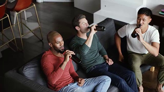头顶拍摄的男性朋友在一间公寓里一起喝啤酒视频素材